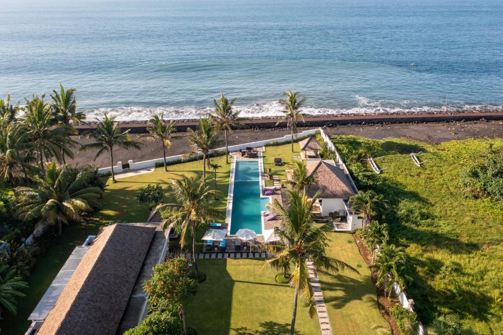 an aerial view of a resort with a swimming pool and the ocean at BougainVilla - Oceanfront villa with Cook, ideal for Weddings and Events in Keramas