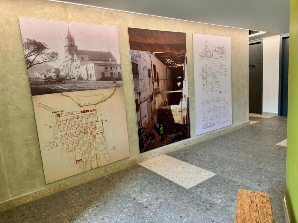 a group of posters on a wall with drawings at Bree Street Apartment - Explore, Eat, Experience Cape Town in Cape Town