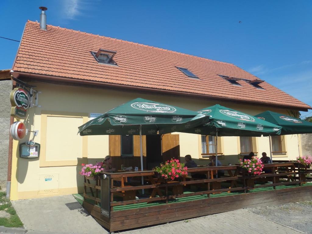 un restaurante con mesas y sombrillas en un edificio en Penzion u Bednářů, en Pavlov