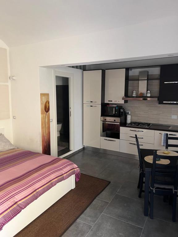 1 dormitorio con cama, mesa y cocina en [FREE PARKING]Appartamento angolo di relax!!!, en Rivoli
