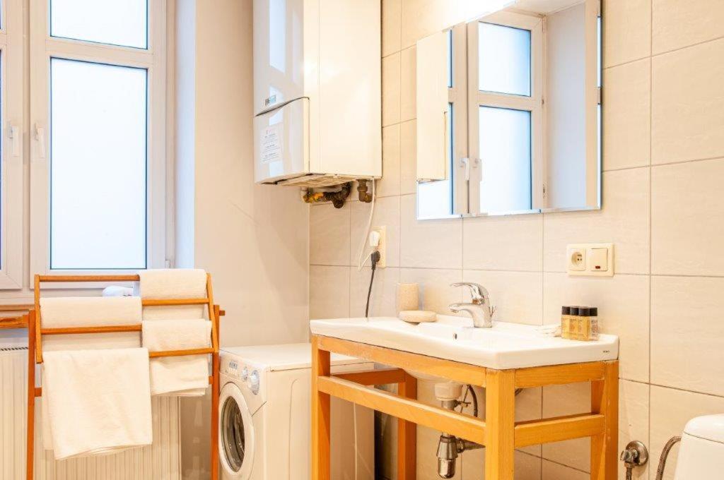 La salle de bains est pourvue d'un lavabo et d'un lave-linge. dans l'établissement Home & Travel, à Łódź