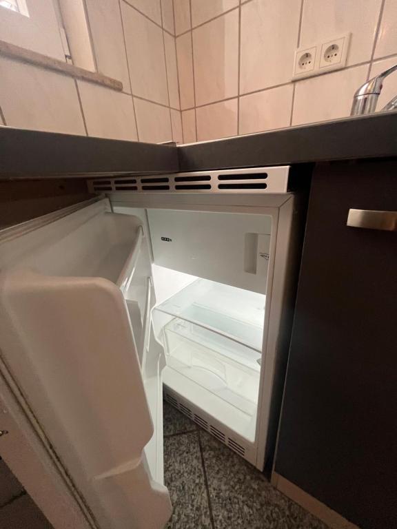 una nevera vacía con la puerta abierta en una cocina en Wohnung im Herzen der Stadt ,Nähe Stadion. en Dortmund