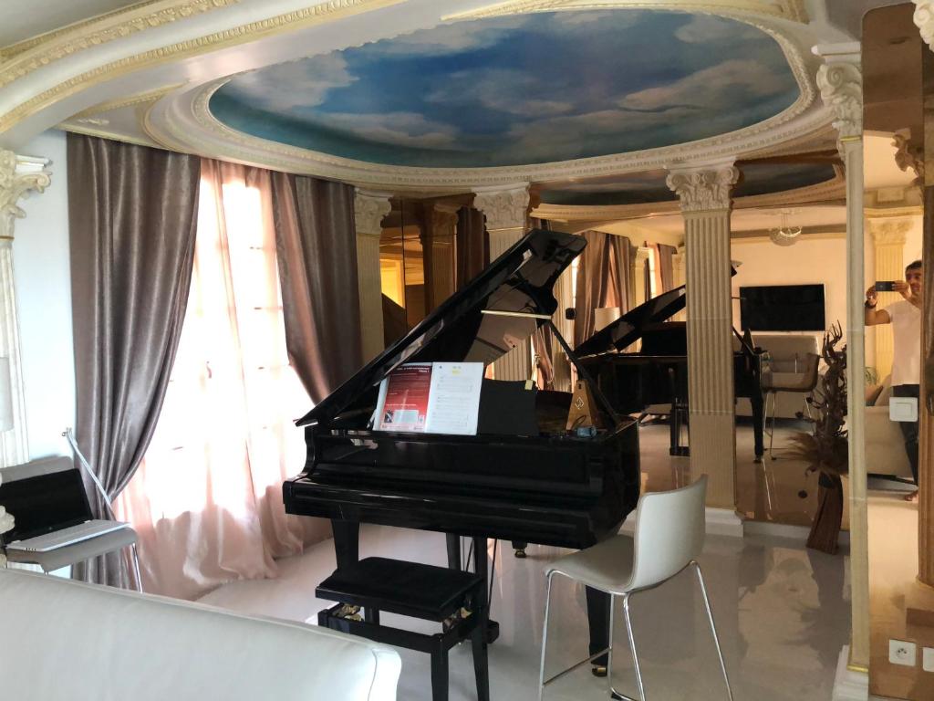 un piano dans un salon avec un plafond dans l'établissement Hôte.Superhost, à Aulnay-sous-Bois