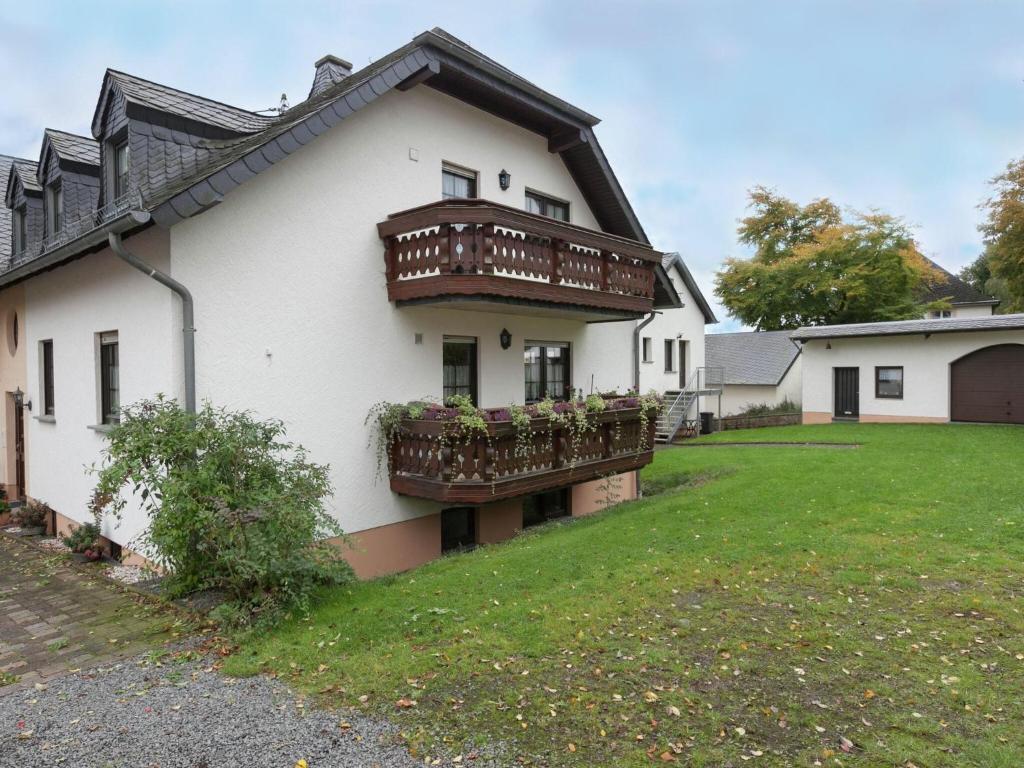 a white house with two balconies and a yard at Apartment with sauna in Eschfeld in Eschfeld