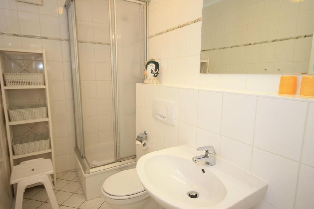 ein Bad mit einem Waschbecken, einer Dusche und einem WC in der Unterkunft Strandschlösschen I WE 11 / 674 in Kühlungsborn
