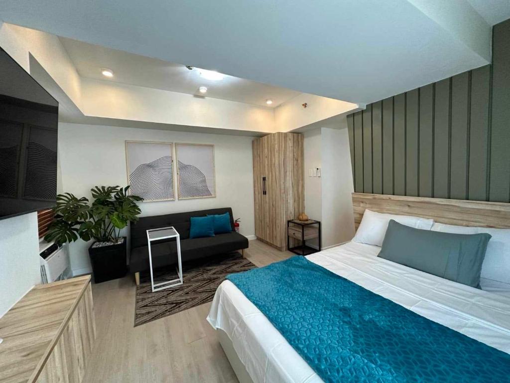 1 dormitorio con 1 cama grande y 1 sofá en 1BR Unit with Spectacular View Monaco Tower 1430A en Del Rosario