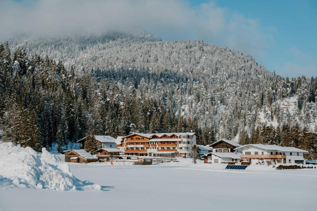 a ski lodge in the snow in front of a mountain at loisi's Boutiquehotel in Achenkirch