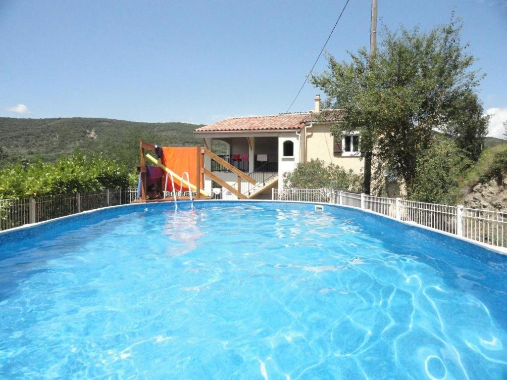 uma grande piscina em frente a uma casa em Les Lauriers roses Vallon Pont d'Arc em Lagorce