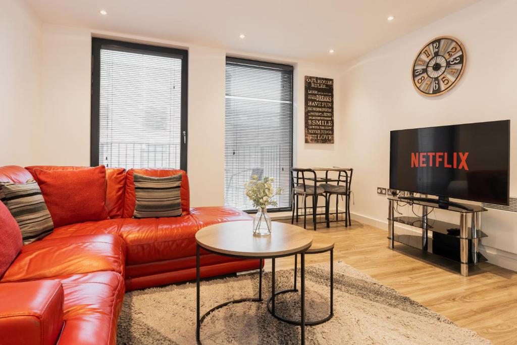 a living room with a couch and a tv at Smart & modern Chester city-centre flat - Sleeps 2 in Chester