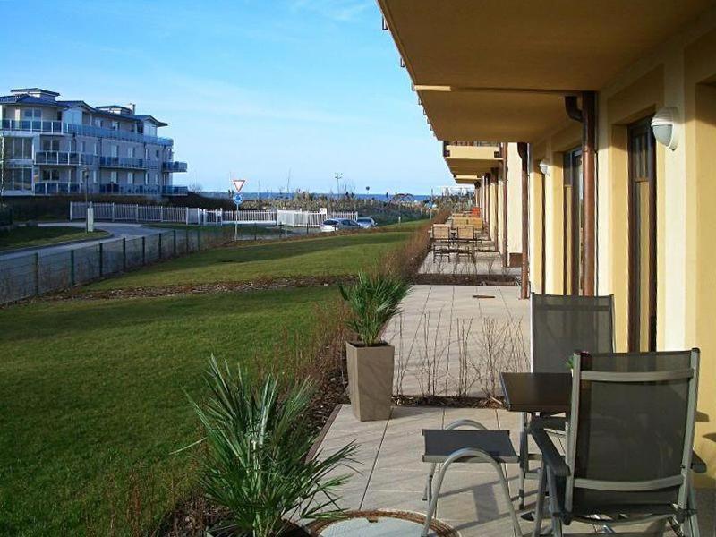 a porch of a building with chairs and a lawn at Urlaubstraeume-am-Meer-Wohnung-4-3-711 in Kühlungsborn