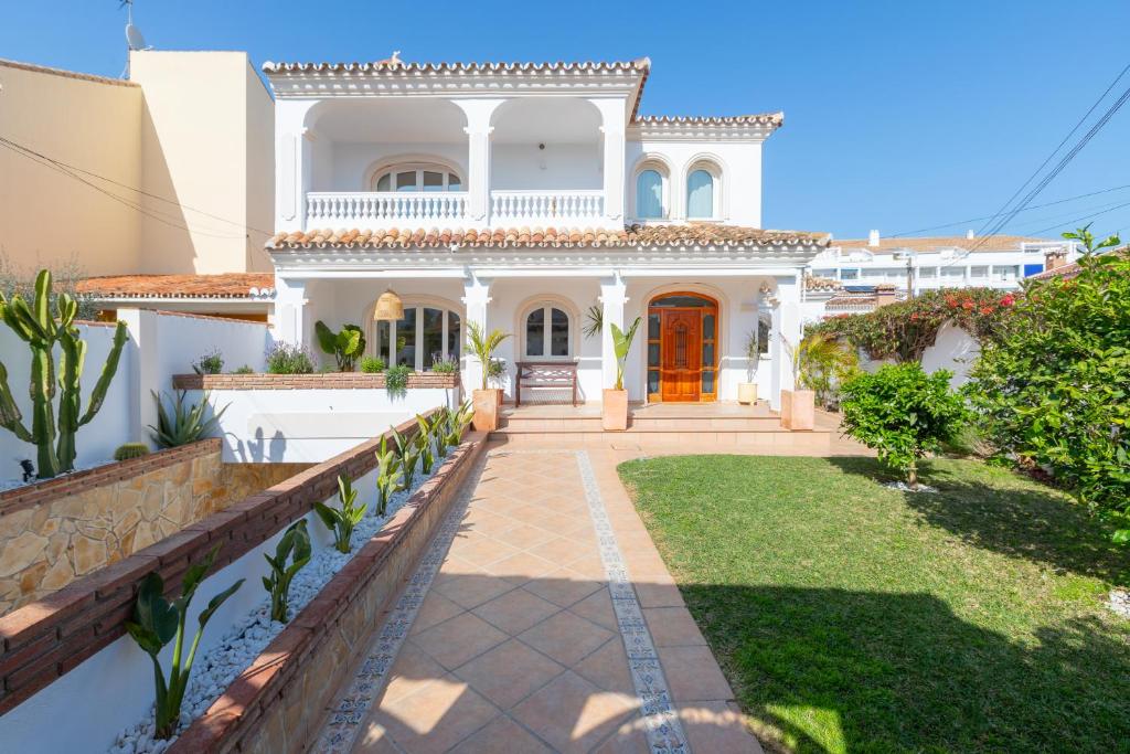 a white house with a pathway in front of it at La casita del Mar in Torremolinos