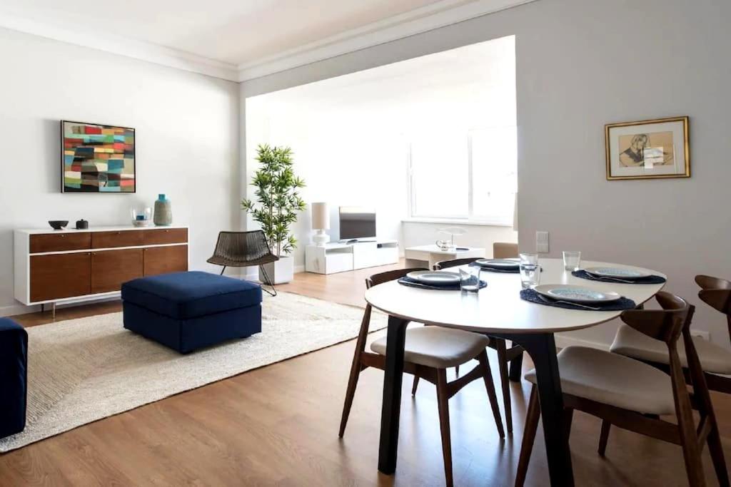 a living room with a table and a blue chair at Elegant and bright apartment in Estoril in Estoril