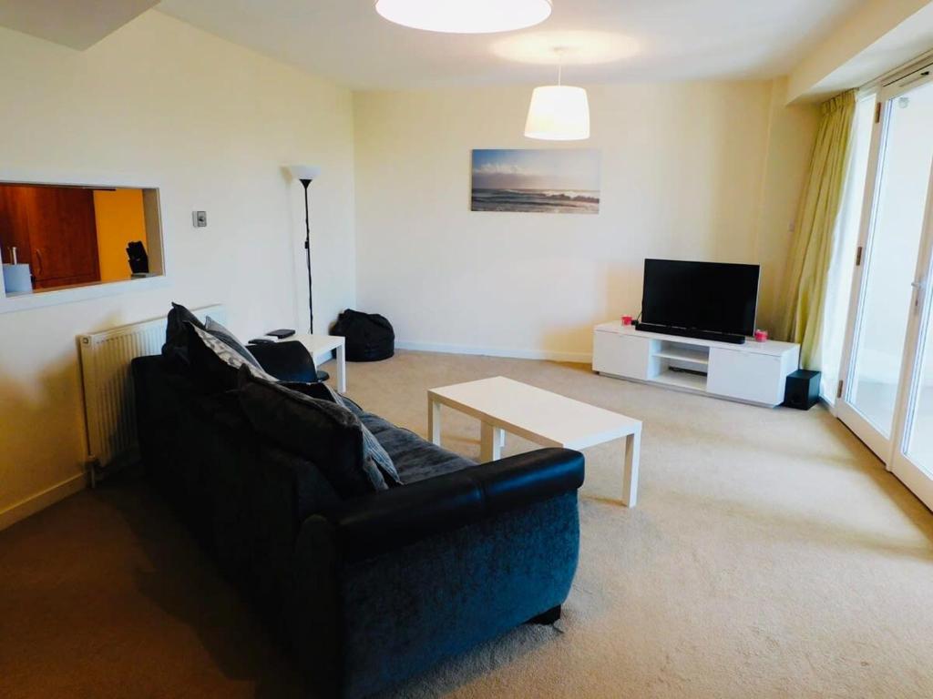 a living room with a couch and a tv at Modern 2 Bed Apartment Close to Gla Airport & M8 in Paisley