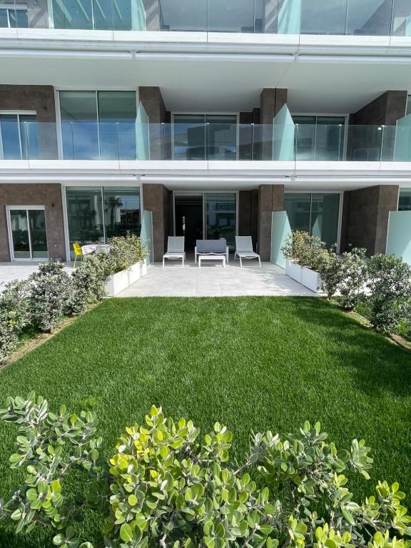 ein großes Gebäude mit einer Rasenfläche davor in der Unterkunft Costa Ballena - Dos dormitorios, Piscina y Jardín privado in Cádiz