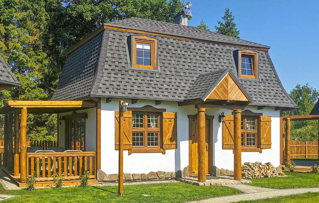 una pequeña casa blanca con techo gris en Beautiful Home In Kopalino With Wifi, en Kopalino