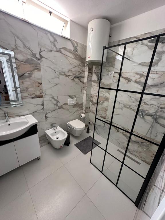bagno con lavandino, doccia e servizi igienici di New Bazaar Studios a Tirana