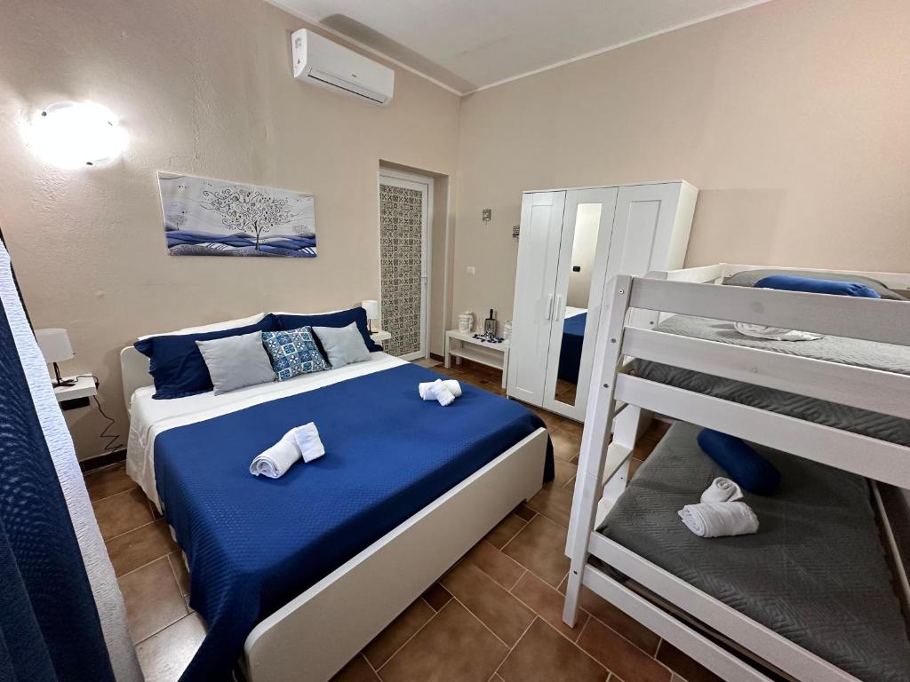 1 dormitorio con 1 cama con sábanas azules y 2 literas en Villa Leale, en Plemmirio