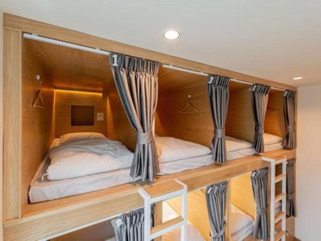duas camas num quarto com cortinas em OYO 75471 Better Zzz em Banguecoque