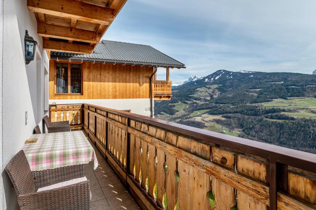 uma varanda com 2 cadeiras e vista para uma montanha em Malsötscherhof Apt B em Villandro