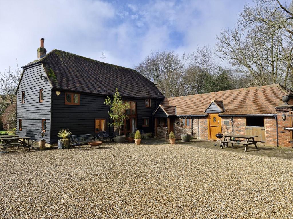 a large black house with a picnic table in front of it at Sussex Barns - Horsham in Horsham