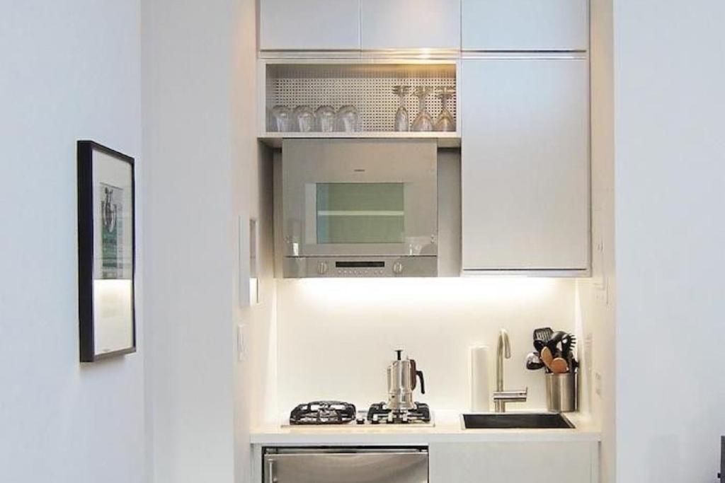 a kitchen with white cabinets and a sink at Kelun accomodations in Nairobi