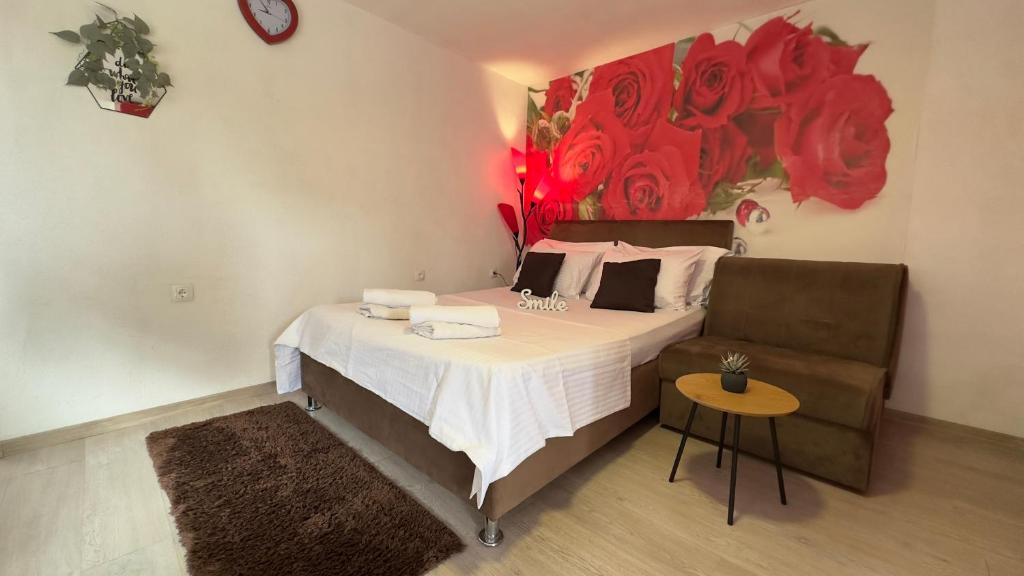 a bedroom with a bed and a chair and a painting at SWEET apartment near Old Town in Mostar