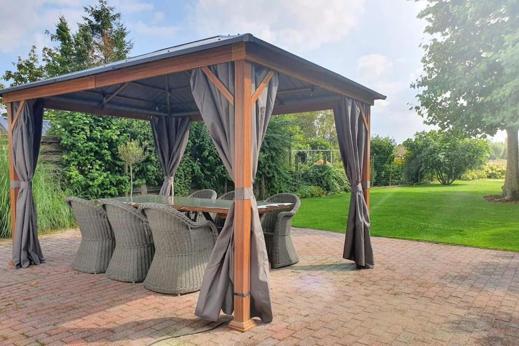 a pavilion with a table and chairs under it at Nature Zeeland in Lamswaarde