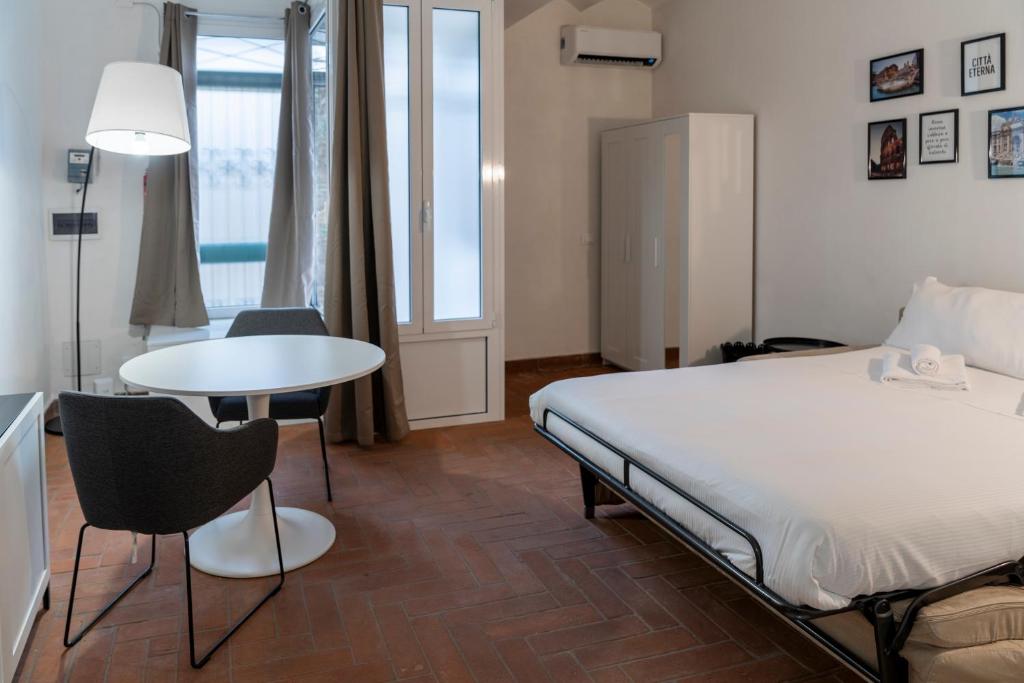 a bedroom with a bed and a table and chairs at Studio Flat - Lungara 44A in Rome