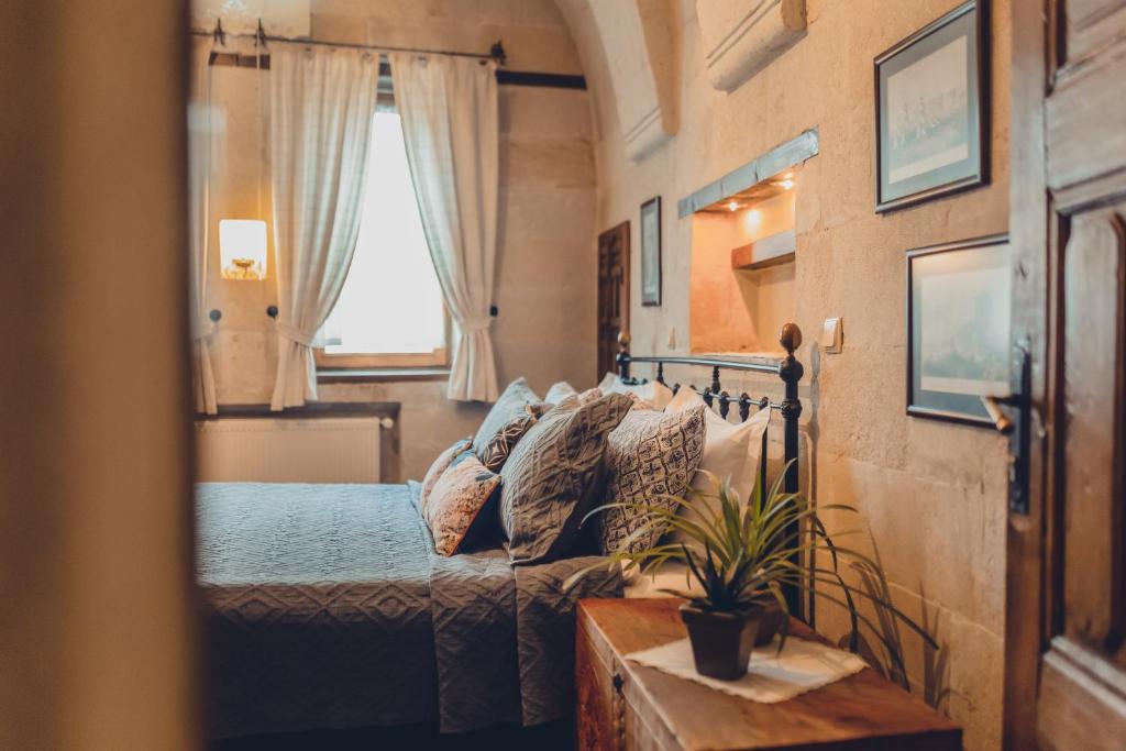 a bedroom with a bed and a couch and a window at Kale Konak Cappadocia in Uçhisar