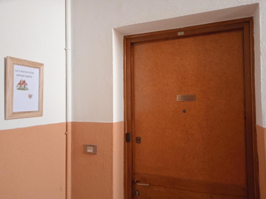una puerta de madera en una habitación con una foto en la pared en La casa di Lucia Appartamento, en Novara