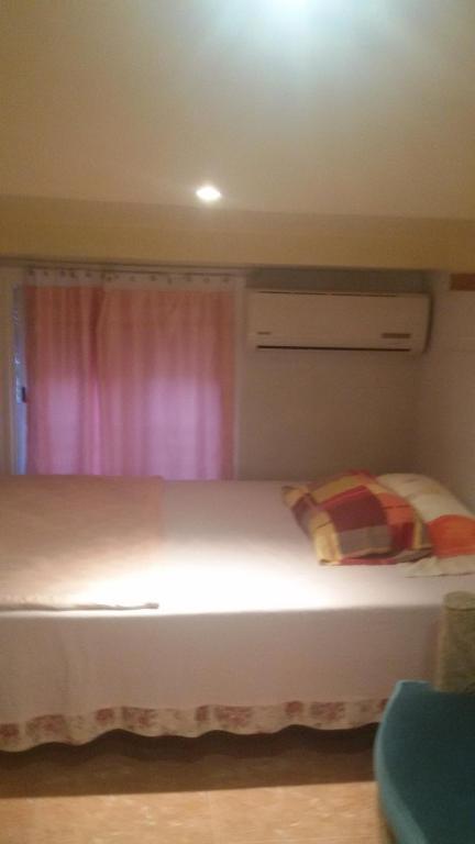 a bedroom with a white bed with a pink curtain at Coliving 54 Buhardilla Numero 3 in El Arrabal