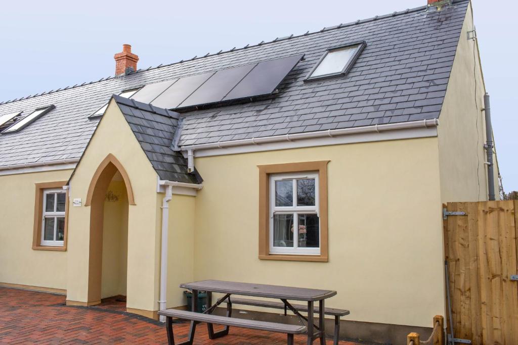 una casa con techo solar y mesa de picnic en Rose Cottage Manorbier, en Manorbier