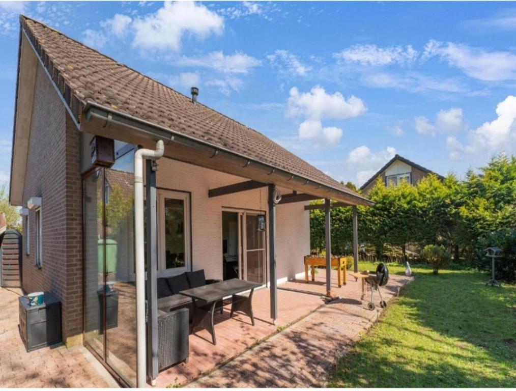 a small house with a patio with a bench at Vakantiehuis vlakbij Duitse grens in Beek