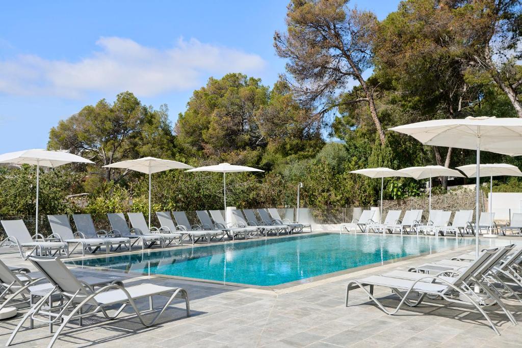 a swimming pool with lounge chairs and umbrellas at Exe Portals Nous in Portals Nous