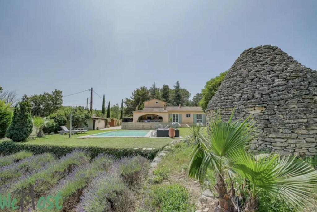 une maison avec un mur en pierre et une cour dans l'établissement Magnifique villa avec piscine village à pied, à Éguilles