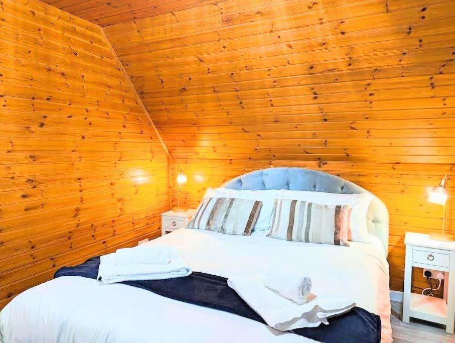 1 dormitorio con 1 cama en una pared de madera en Balor 1 - Hot Tub-Perth-Pets, en Perth