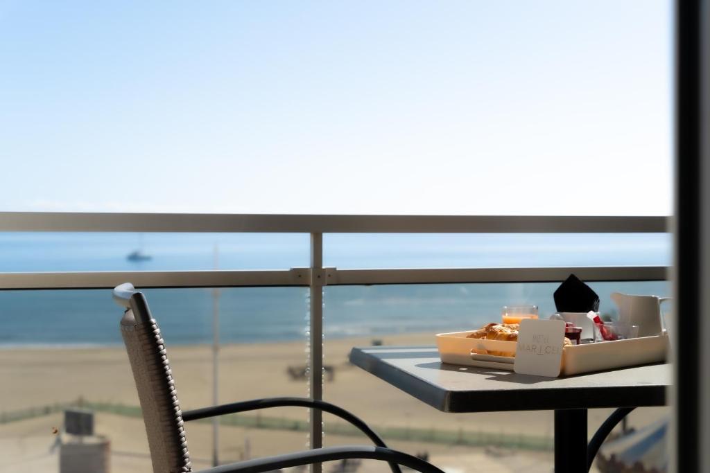 a table with a box of food and a chair at Hôtel Mar I Cel &amp; Spa in Canet-en-Roussillon