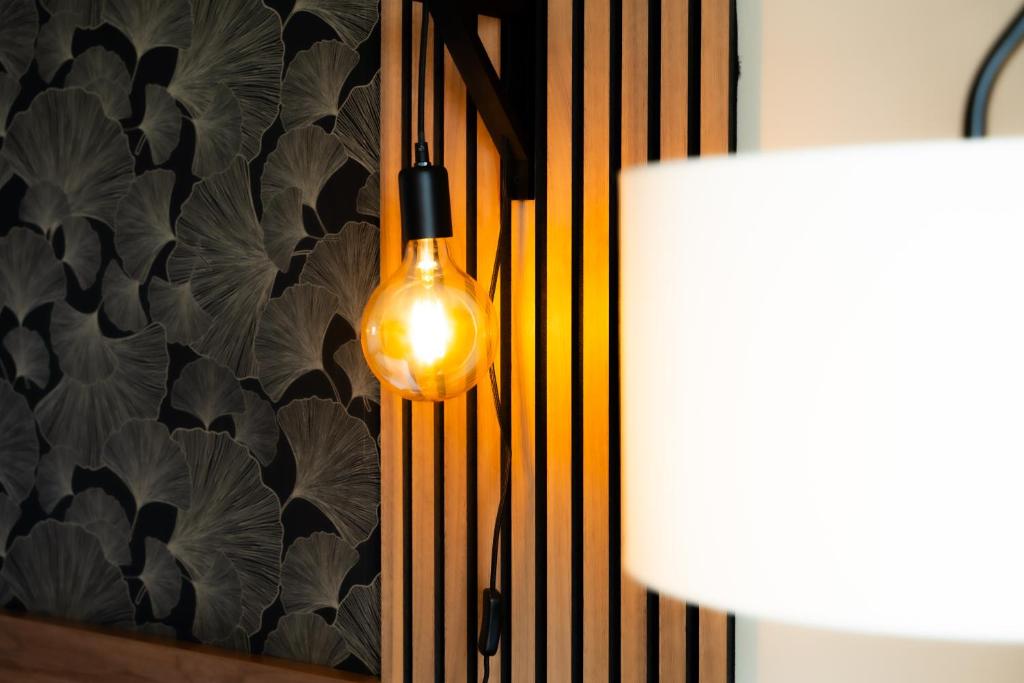 a light bulb hanging from a wall next to a lamp at Hôtel Mar I Cel &amp; Spa in Canet-en-Roussillon