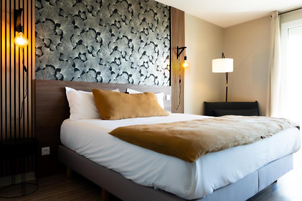 a bedroom with a large bed with a black and white wall at Hôtel Mar I Cel &amp; Spa in Canet-en-Roussillon