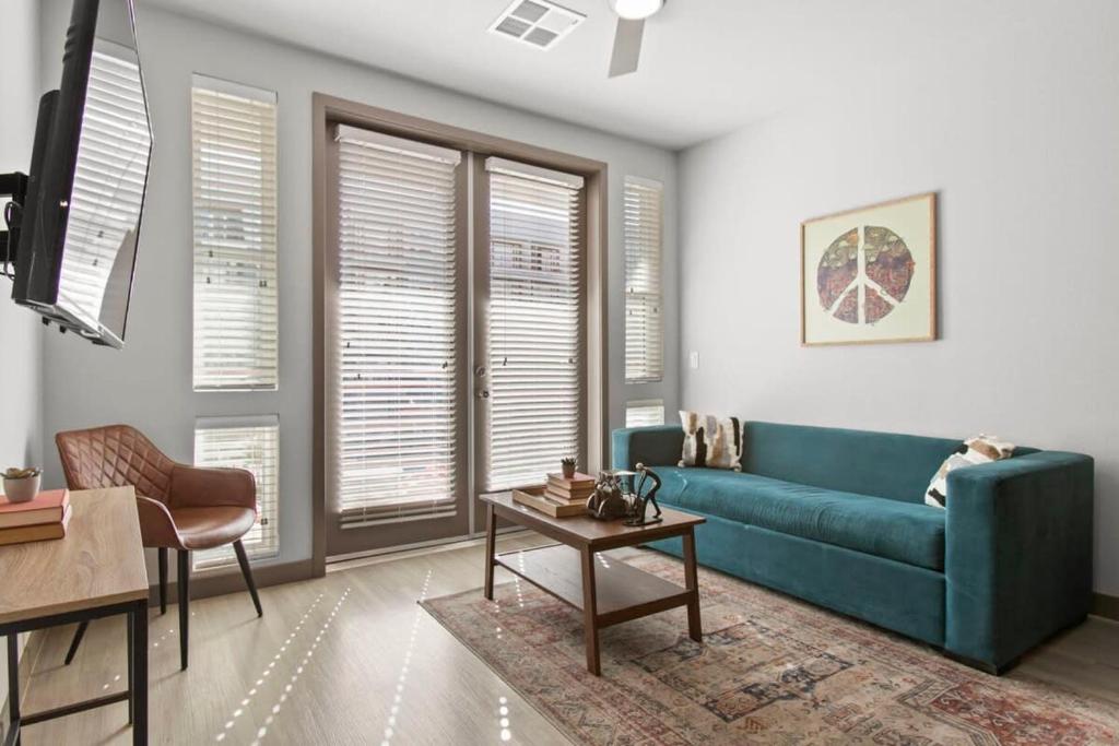 a living room with a blue couch and a table at Cozysuites PHX RORO Gym Pool Pets Parking #12 in Phoenix