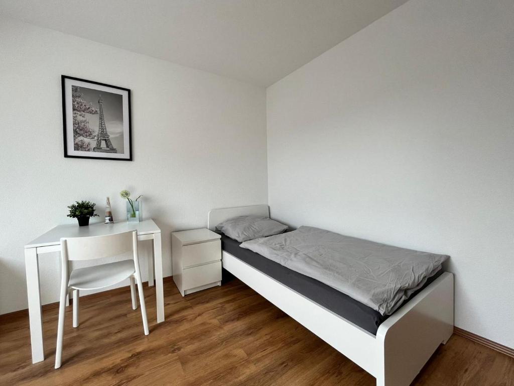 Habitación pequeña con cama y escritorio. en Eterna Smart Living en Krefeld