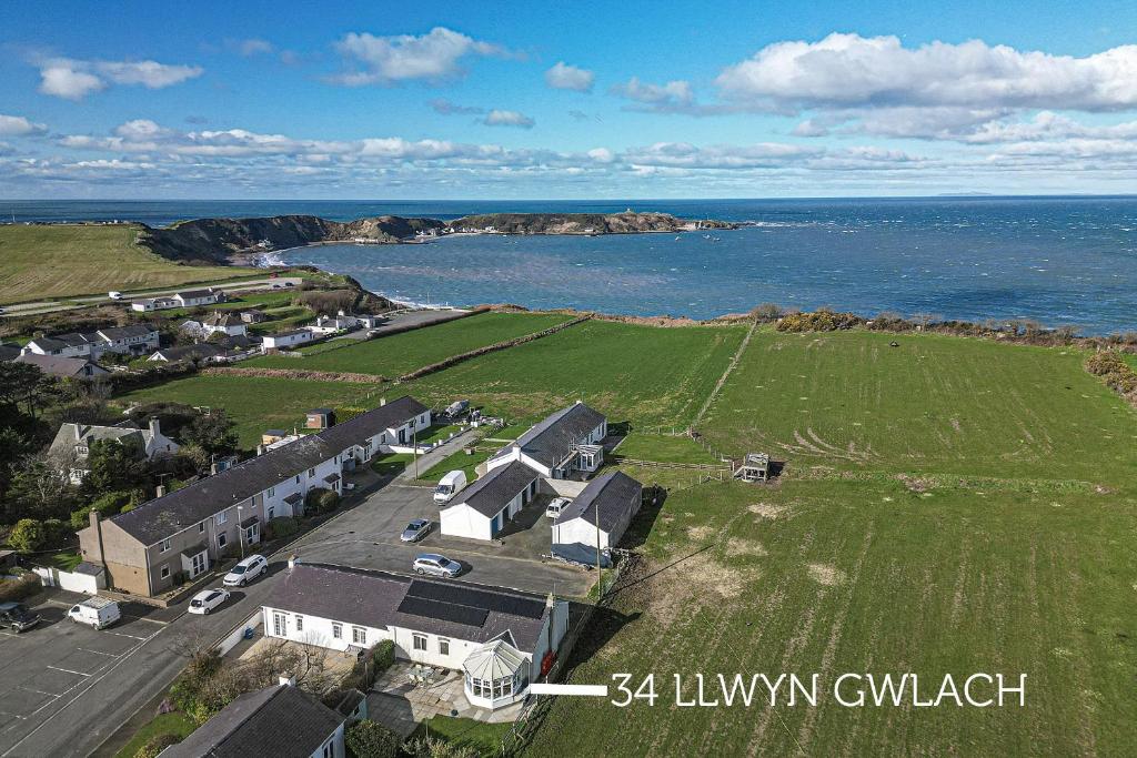 an aerial view of a house next to the ocean at 34 Llwyn Gwalch in Morfa Nefyn