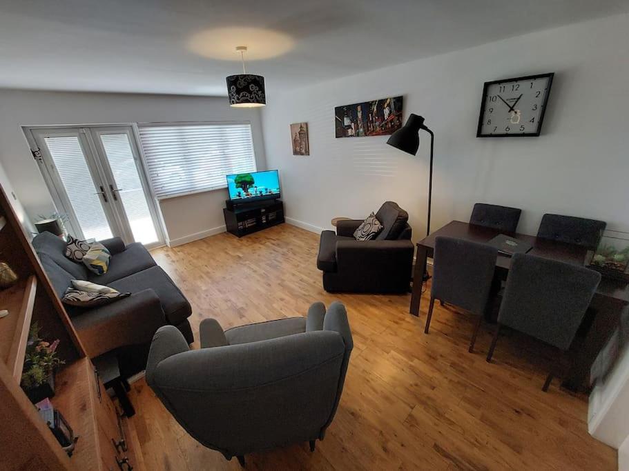 sala de estar con sofá, sillas y TV en Paisley Pineapple Flat Central UWS Glasgow Airport en Paisley