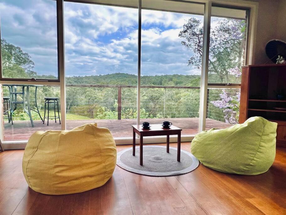 Wonga Park的住宿－Perfect View Retreat in Forest，客厅配有2把黄色椅子和桌子