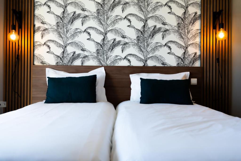 two beds in a hotel room with a wallpaper at Hôtel Mar I Cel &amp; Spa in Canet-en-Roussillon