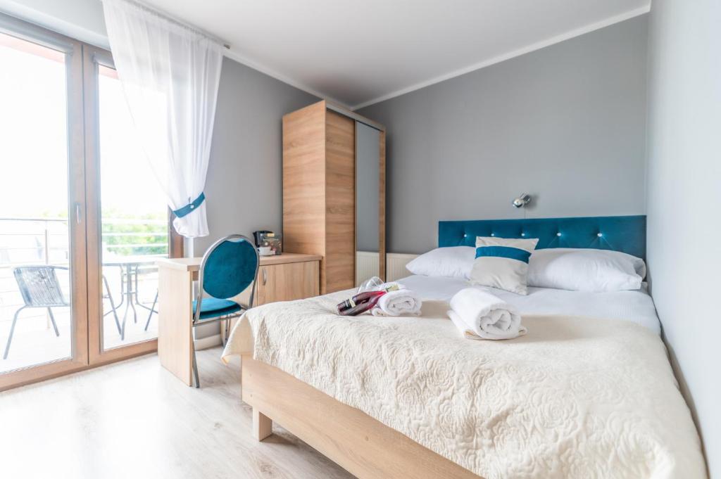 a bedroom with a large bed with towels on it at ReveliQa2 in Pobierowo