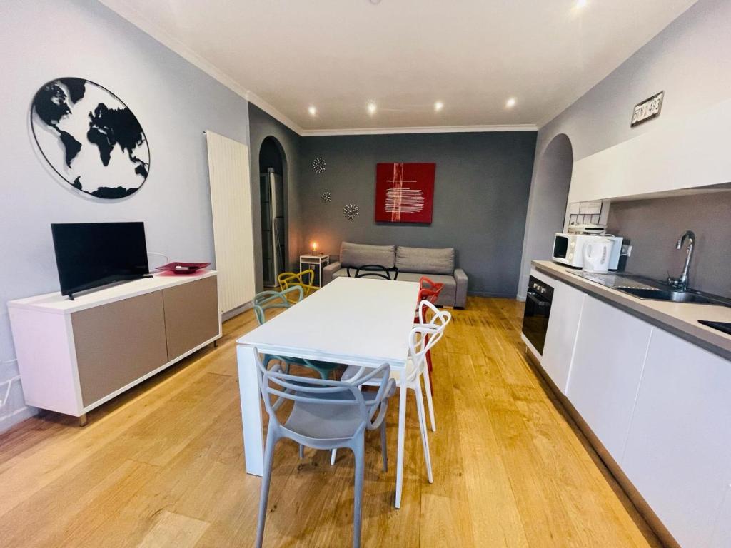 una cucina e un soggiorno con tavolo e sedie bianchi di Casa Santarelli a Roma