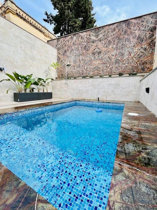 a swimming pool with blue water in front of a building at Seafront Beach House in St.Julians in Sliema