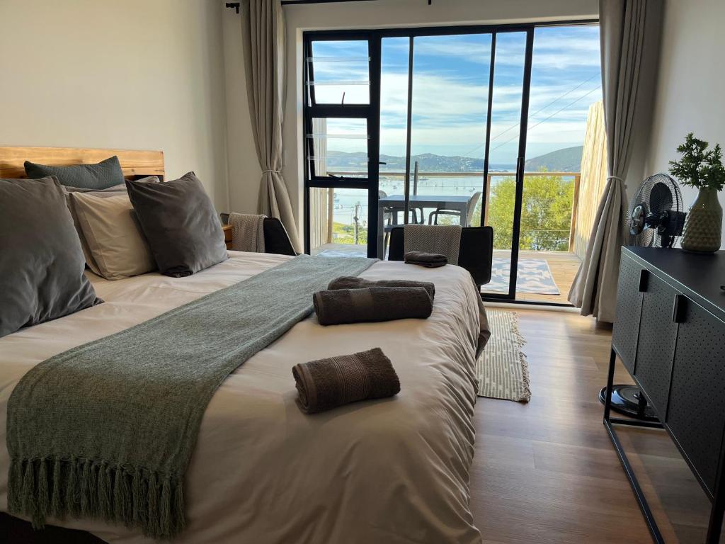 una camera da letto con un grande letto con una grande finestra di De View a Knysna