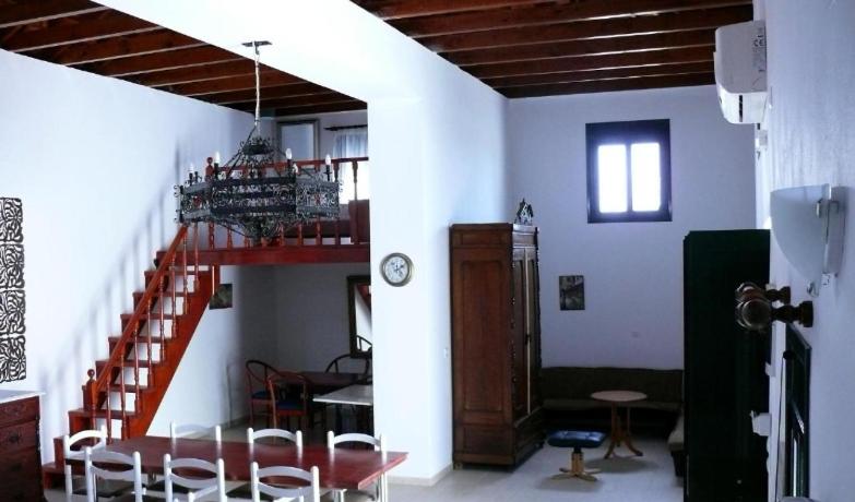 a room with a staircase and a table and chairs at Villa Rosa in Kattavía